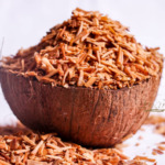 Noir, orange et brun, noix de coco râpée dans un bol en bois, texture naturelle, épices, décoration, style rustique, alimentation saine, image appétissante, concept culinaire, sélection de produits naturels, cuisine saine, alimentation équilibrée, ingrédients bio, vibes tropicales.