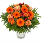 Fleuri orange avec roses et feuillage vert dans un vase en verre.